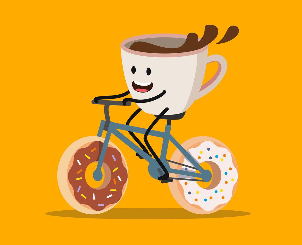 تصویر یک ماگِ خوشحال با قهوه ی درونش که بر روی دوچرخه ی ساخته شده از دونات در حال حرکت است.
